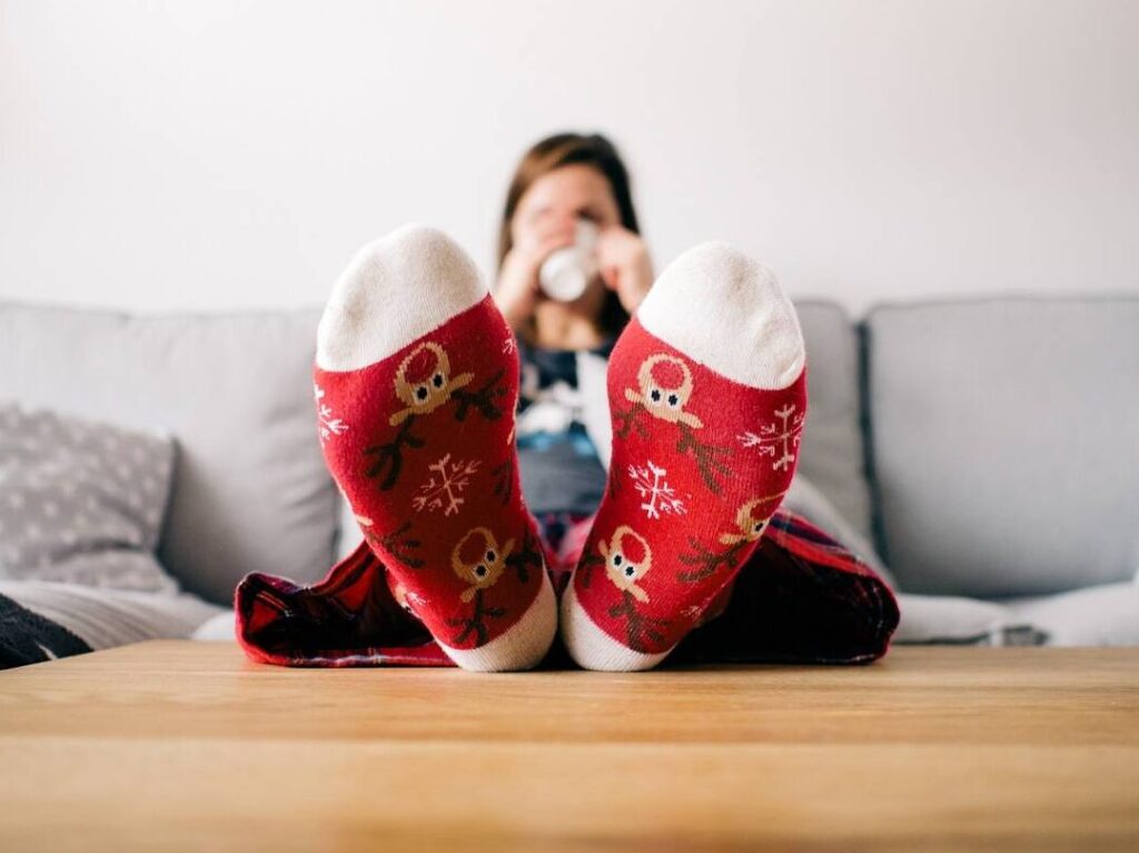 femme en chaussettes pieds sur la table