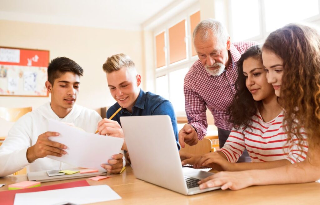 Étudiants utilisant un ordinateur pour se connecter à Scolinfo, la plateforme de suivi scolaire numérique.