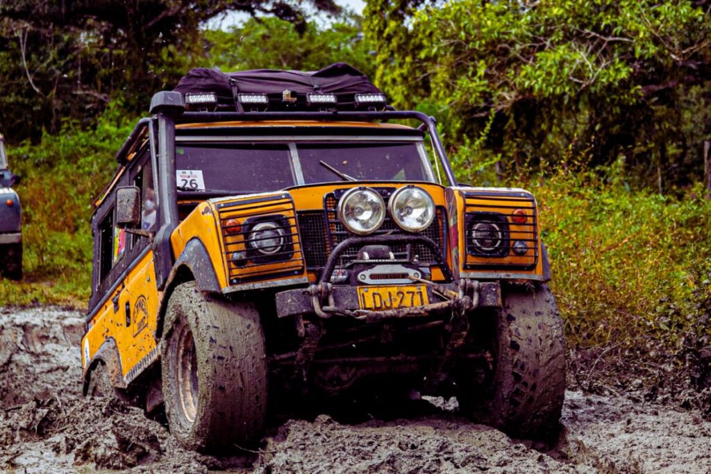 Land Rover orange vibrant lors d'une excursion en pleine nature, symbole de la passion des landistes.